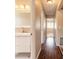 Bright hallway with a modern sink and vanity, leading to sunlit bedrooms with hardwood floors at 2819 Silver Palm Dr, Edgewater, FL 32141