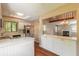 Modern kitchen with stainless steel appliances and a view of the living room with a fireplace and staircase at 2819 Silver Palm Dr, Edgewater, FL 32141