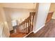A traditional staircase with wooden banister leads to the lower level with durable wood flooring at 2819 Silver Palm Dr, Edgewater, FL 32141