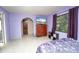 Cozy bedroom with purple walls, a large window, and neutral patterned flooring at 291 Sagewood Dr, Port Orange, FL 32127