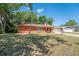 Charming brick home with a manicured lawn and mature trees on a sunny day at 291 Sagewood Dr, Port Orange, FL 32127