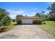 Detached garage with a concrete driveway and some shrubs at 2919 Griffin Rd, Leesburg, FL 34748