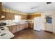 Outdated kitchen features wood cabinets, white appliances, and a tile backsplash that needs updating at 2919 Griffin Rd, Leesburg, FL 34748