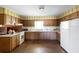 An outdated kitchen showcasing wooden cabinets, a white refrigerator, and dark floor that could use some modern updates at 2919 Griffin Rd, Leesburg, FL 34748