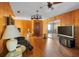 Spacious living room with wood paneling, glass table, and a sliding glass door to the sunroom at 2919 Griffin Rd, Leesburg, FL 34748