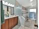 Bright bathroom features dual sinks, glass block window, and walk-in shower with neutral color tile at 2937 Garret St, Deltona, FL 32738