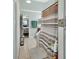 Hallway to a bathroom with a brown shower curtain and mosaic tile accent, tile flooring, and mint green walls at 2937 Garret St, Deltona, FL 32738