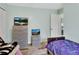 Bedroom with light green walls, wood-look floors, television, and two twin beds with colorful bedding at 2937 Garret St, Deltona, FL 32738