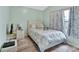 Bright bedroom with a queen bed, white comforter, floral curtains, wood-look flooring, and pastel-painted walls at 2937 Garret St, Deltona, FL 32738