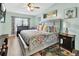Bright bedroom featuring a ceiling fan, artwork, bedside table, and a patterned comforter at 2937 Garret St, Deltona, FL 32738