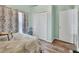 Bedroom features a white closet, white doors, wood-look flooring, floral curtains, and pastel-painted walls at 2937 Garret St, Deltona, FL 32738