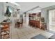 Open-concept kitchen and dining room with an island, bar stools, and tiled flooring at 2937 Garret St, Deltona, FL 32738