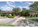 Inviting single-story brick home with a well-manicured lawn, a variety of trees, and a concrete driveway leading to the entrance at 3 Whipper In Cir, Ormond Beach, FL 32174