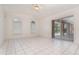 Bright living room with white tile flooring, ceiling fan, and sliding glass doors to the pool area at 3 Whipper In Cir, Ormond Beach, FL 32174