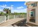 Wooden deck with white railings and a door, perfect for enjoying outdoor living at 3000 Ocean Shore Blvd # 6, Ormond Beach, FL 32176