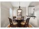 Cozy dining area with a round glass table, wicker chairs, and modern light fixture at 3000 Ocean Shore Blvd # 6, Ormond Beach, FL 32176