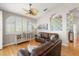 Comfortable living room featuring hardwood floors, ceiling fan, and an arched window with plantation shutters at 3000 Ocean Shore Blvd # 6, Ormond Beach, FL 32176