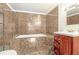 Bathroom with tiled walls, a tub, shower, and cherry wood vanity at 313 Dirksen Dr # G4, Debary, FL 32713