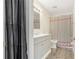 Well-lit bathroom with a modern vanity, coordinating fixtures, and shower/tub with decorative curtain at 313 Dirksen Dr # G4, Debary, FL 32713