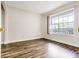 Sunlit bedroom with wood laminate flooring, fresh paint, and a large window at 313 Dirksen Dr # G4, Debary, FL 32713