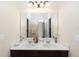 Bright bathroom features double sinks with a large mirror and contemporary lighting at 319 E Victoria Trails Blvd, Deland, FL 32724