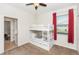 Cozy bedroom showcasing a bunk bed, ceiling fan, and window with bright red curtains at 319 E Victoria Trails Blvd, Deland, FL 32724