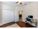 Bedroom with hardwood flooring, closet, ceiling fan, and small desk space at 319 E Victoria Trails Blvd, Deland, FL 32724