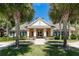 Community clubhouse featuring a well-manicured lawn and symmetrical palm trees at 319 E Victoria Trails Blvd, Deland, FL 32724