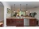 Kitchen island with stainless steel dishwasher, granite countertop and dark wood cabinets at 319 E Victoria Trails Blvd, Deland, FL 32724