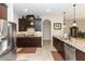Kitchen with stainless steel appliances, dark cabinets, granite countertops, and arched doorway at 319 E Victoria Trails Blvd, Deland, FL 32724