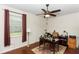 Office with a desk, wooden floors, a ceiling fan and a large window with red curtains at 319 E Victoria Trails Blvd, Deland, FL 32724