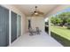 Covered patio with ceiling fan, patio furniture and sliding glass doors overlooking the lawn at 319 E Victoria Trails Blvd, Deland, FL 32724