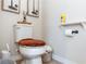Close-up of toilet with brown fuzzy seat cover, toilet paper, and wall decorations at 319 E Victoria Trails Blvd, Deland, FL 32724