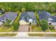 Stunning aerial view of a charming yellow house with lush landscaping and a brick driveway at 341 Chelsea Place Ave, Ormond Beach, FL 32174
