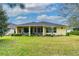Expansive backyard features mature trees, lush lawn, and a screened patio at 341 Chelsea Place Ave, Ormond Beach, FL 32174