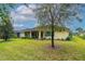 Expansive backyard features mature trees, lush lawn, and a screened patio at 341 Chelsea Place Ave, Ormond Beach, FL 32174