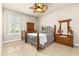 Comfortable bedroom with a ceiling fan, window with shutters, and tile floors at 341 Chelsea Place Ave, Ormond Beach, FL 32174
