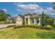 Inviting yellow home boasting manicured landscaping, a brick driveway, and a charming front porch at 341 Chelsea Place Ave, Ormond Beach, FL 32174