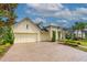 Inviting yellow home boasting manicured landscaping, a brick driveway, and a charming front porch at 341 Chelsea Place Ave, Ormond Beach, FL 32174
