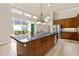A modern kitchen with wooden cabinets, a granite island, and stainless steel appliances at 341 Chelsea Place Ave, Ormond Beach, FL 32174