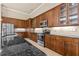 A modern kitchen with wooden cabinets, granite countertops, and stainless steel appliances at 341 Chelsea Place Ave, Ormond Beach, FL 32174