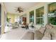 This beautiful lanai has white wicker furniture and a ceiling fan at 341 Chelsea Place Ave, Ormond Beach, FL 32174