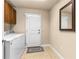 Utility room with modern washer and dryer, storage cabinets, and exterior access door at 341 Chelsea Place Ave, Ormond Beach, FL 32174