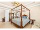 Well-lit primary bedroom features a four-poster bed and an ensuite bathroom at 341 Chelsea Place Ave, Ormond Beach, FL 32174