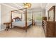 Inviting primary bedroom showcases a four-poster bed, ceiling fan, and shuttered windows at 341 Chelsea Place Ave, Ormond Beach, FL 32174