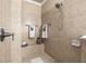 Neutral tiled shower with a built-in bench, and hand-held shower fixture at 341 Chelsea Place Ave, Ormond Beach, FL 32174