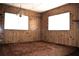 A bedroom featuring wood-paneled walls, two windows, and brown carpet creates a cozy atmosphere at 34416 Oak Ave, Leesburg, FL 34788