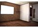 View of the bedroom with wood-paneled walls, access to the bathroom, carpeted floor, and a window at 34416 Oak Ave, Leesburg, FL 34788