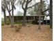 An exterior view of this charming home, highlighting a spacious yard with lush greenery at 34416 Oak Ave, Leesburg, FL 34788
