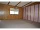 Bright living room with wood paneling, large window, and neutral carpeting, offering a comfortable space at 34416 Oak Ave, Leesburg, FL 34788